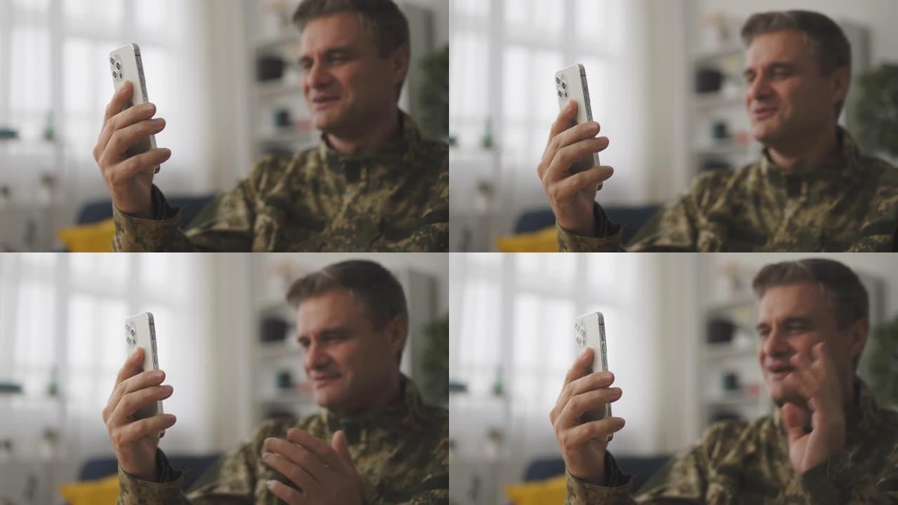 微笑的中年男性士兵用智能手机进行视频通话的特写