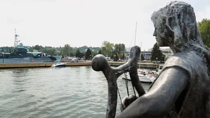 雕像装饰老式船只离开港口前往公海，招待游客