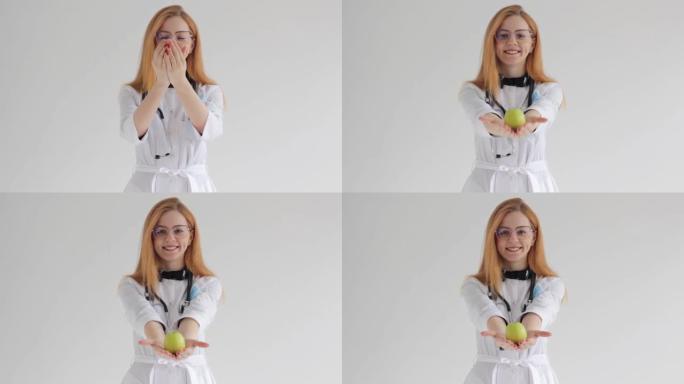 一位面带微笑的红发女医生手里拿着一个青苹果，提出了适当健康营养的概念。