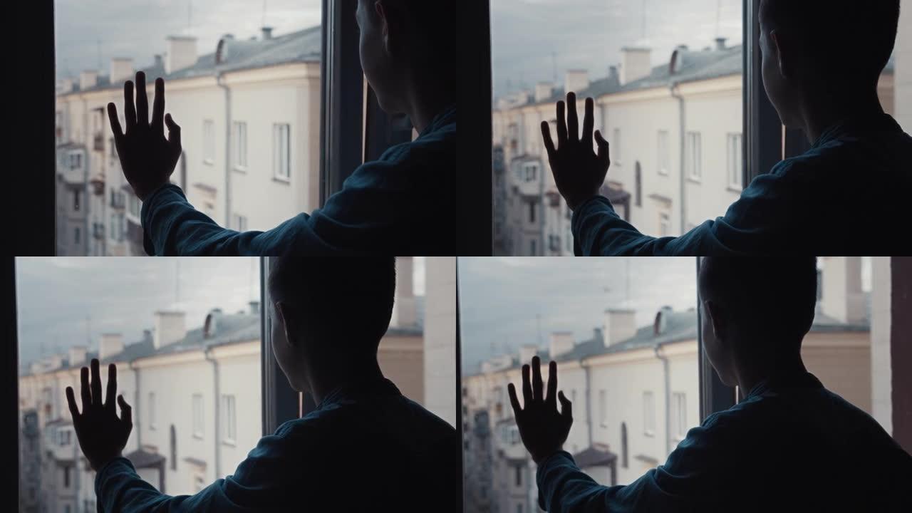 男孩站在窗边，看着房子的屋顶，童年的经历，电影般的镜头