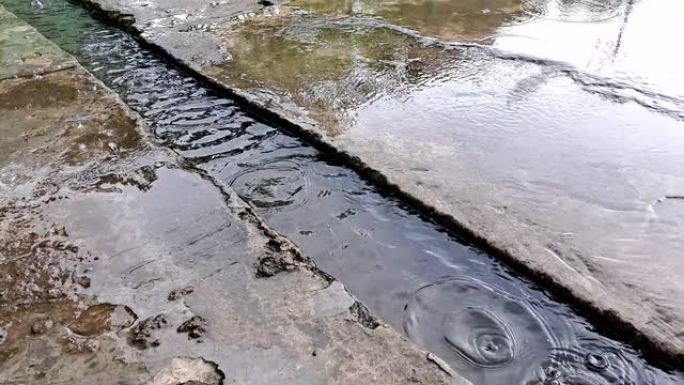 下雨时，水泥沟向河水流动