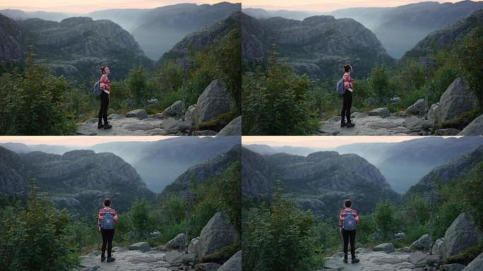 在Lysefjorden的背景下在山上徒步旅行的女人