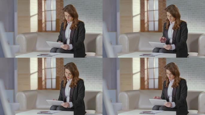 漂亮的女商人使用平板电脑对着凸轮微笑。在线约会