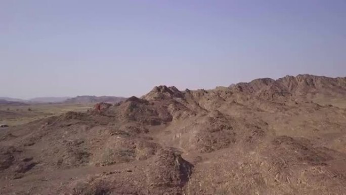 在沙漠中攀登落基山的越野跑者的鸟瞰图