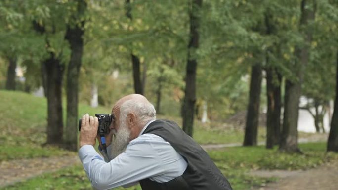 老人在公园里拍摄大自然的照片