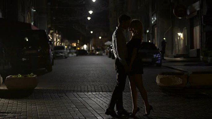 两个相爱的人在夜街温柔地接吻，在大城市相爱，约会