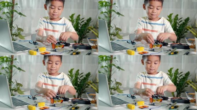 亚洲小男孩拼装板成机器人汽车作业