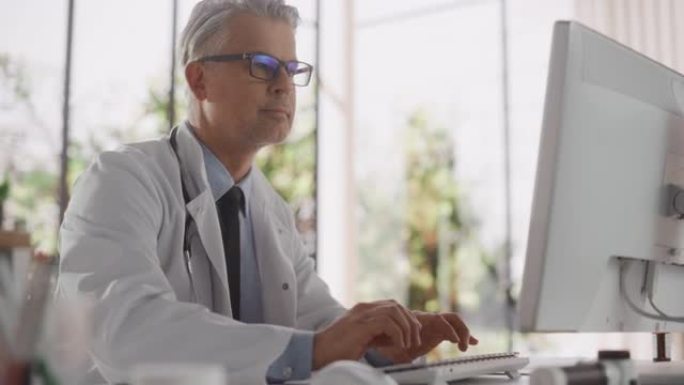 经验丰富的中年男性医生，穿着白大褂，在办公室用个人电脑工作。英俊的医疗保健专业人员与检测结果，患者治