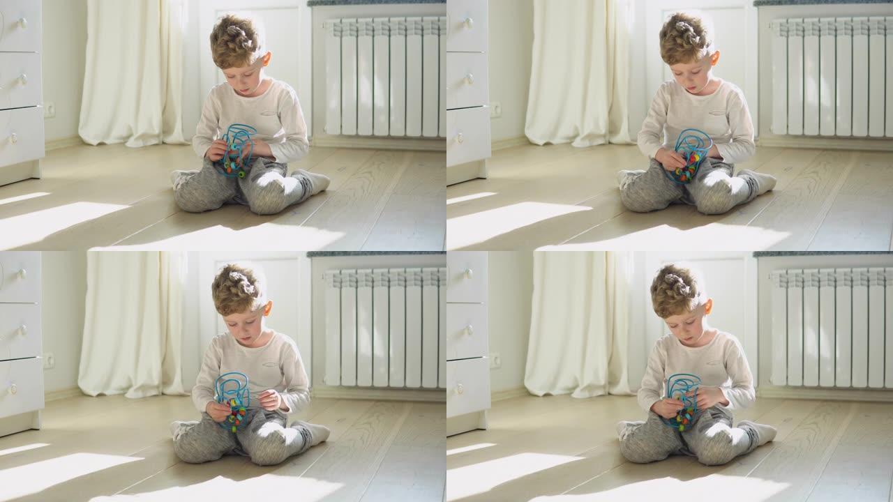 小男孩在托儿所的地板上玩教育逻辑玩具