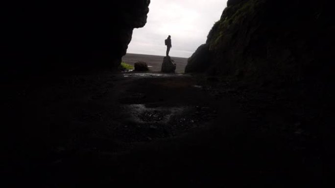 站在Gigjagja Cave入口处的一名男子的倾斜镜头