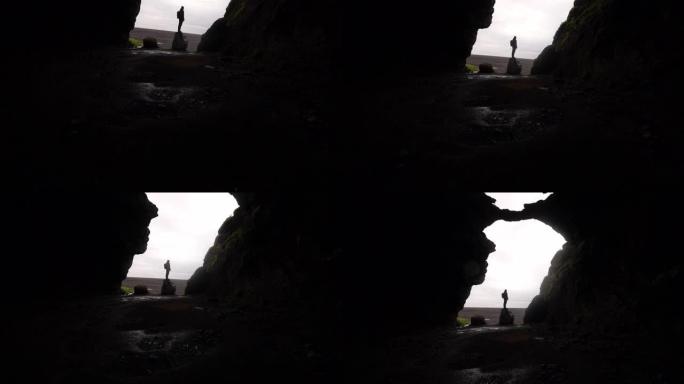 站在Gigjagja Cave入口处的一名男子的倾斜镜头