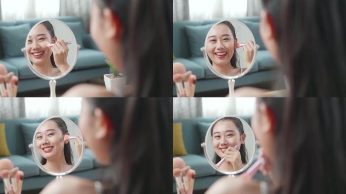 镜子里的倒影美丽的年轻亚洲妇女在家里化妆时，她的脸颊和微笑