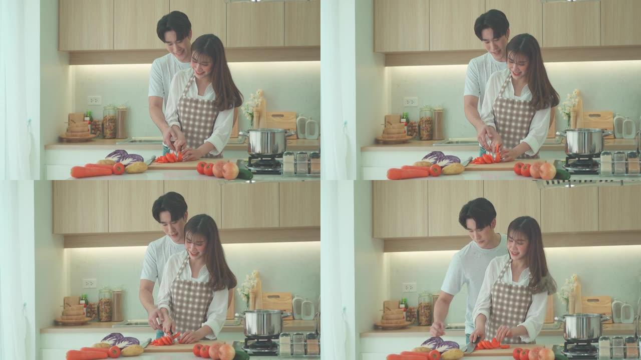 亚洲夫妇正在家里的厨房里帮忙切胡萝卜做鸡汤。一对情侣的浪漫场景