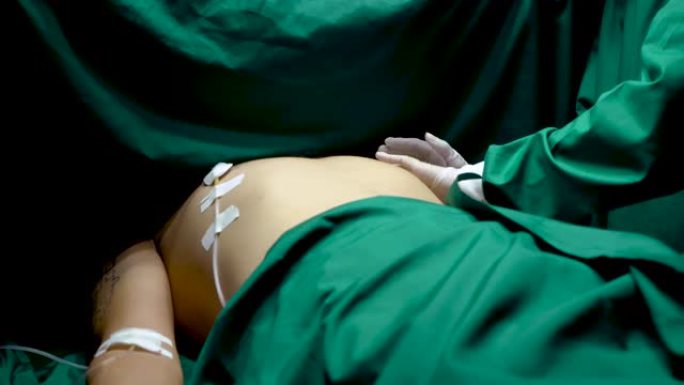 4K，男子躺在手术室里，医生正在安装手术器械，将胸部贴在患者的躯干上，长管状器械，医生将一块绿色的布