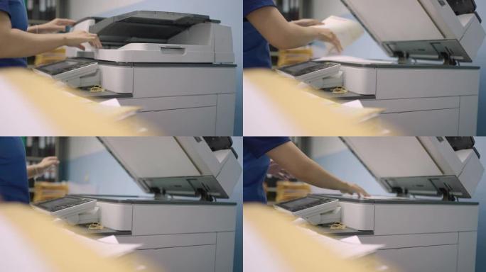 通过使用多功能复印机复印文件来处理文件的女性工人。