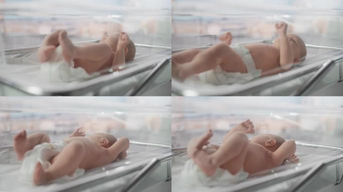 可爱的高加索新生婴儿躺在产科医院的摇篮里。一个顽皮而充满活力的孩子的肖像。医疗保健、怀孕和孕产概念