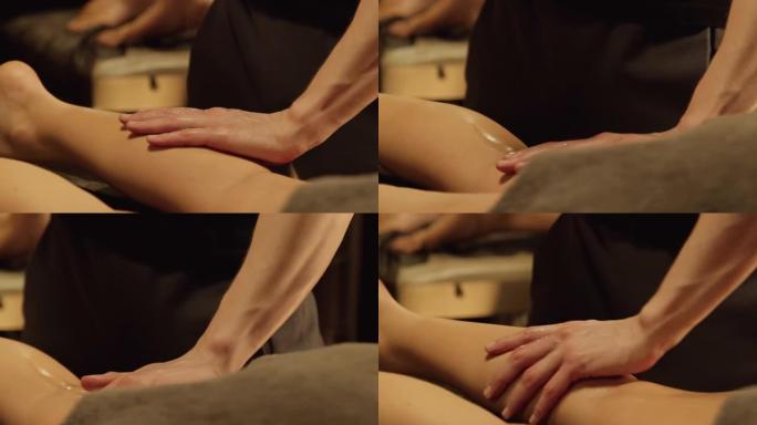 按摩师按摩女人小腿肌肉。腿部按摩的特写。身体护理概念