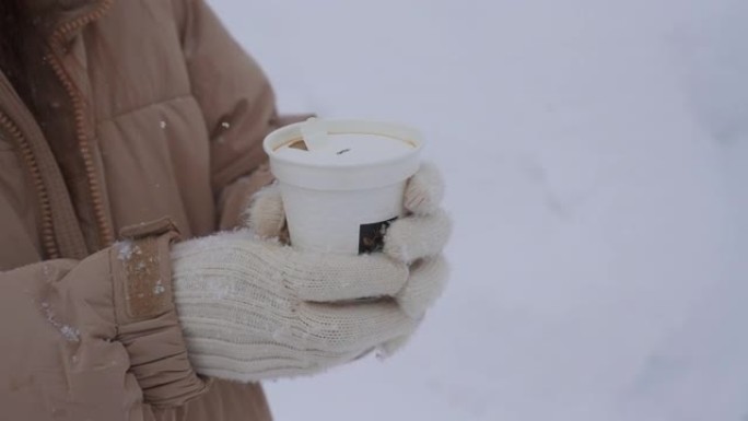 在下雪时拿着咖啡杯