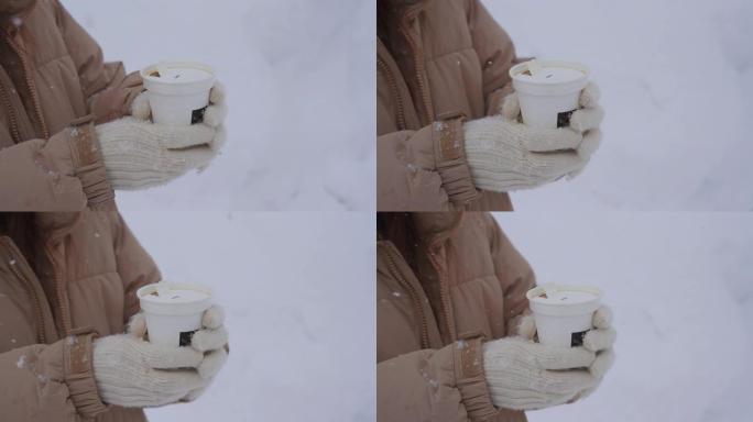 在下雪时拿着咖啡杯