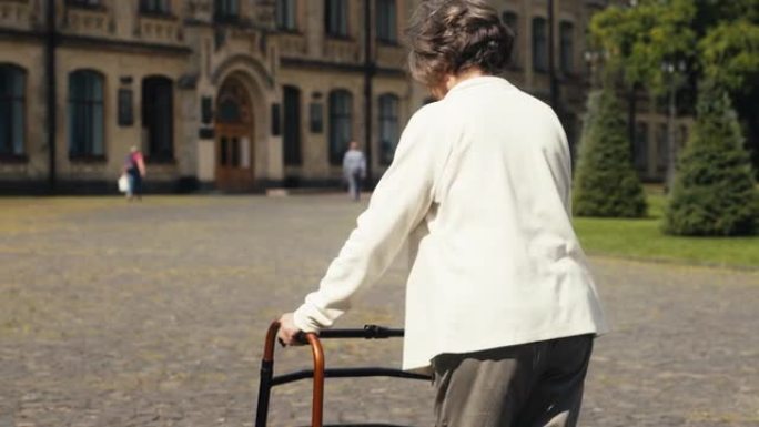 残疾老年妇女使用步行框架在医院场所行走