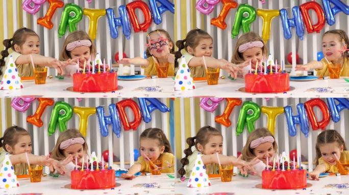 三个有趣的小女孩在生日聚会上，他们伸手拿蜡烛蛋糕
