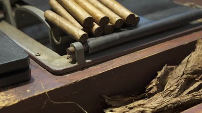 制作手卷雪茄的木桌。干燥的烟叶和包装的优质古巴雪茄。世界上最好的雪茄