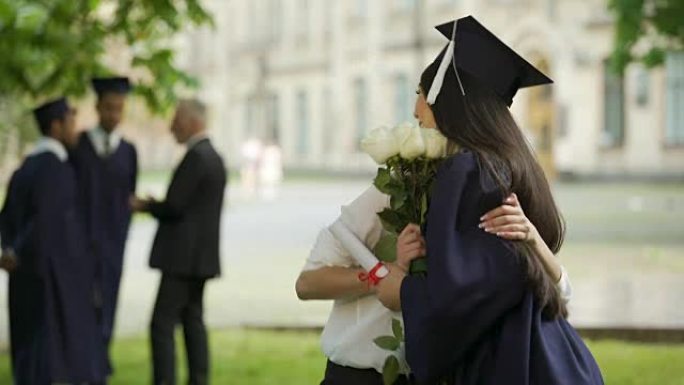 大学女毕业生等待朋友前来送花拥抱