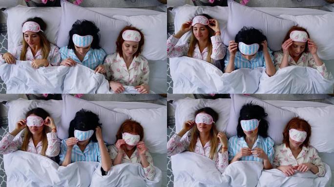 俯视图，三个漂亮的女孩在床上睡觉，并戴上眼圈绷带睡觉