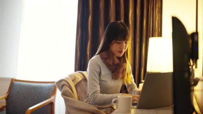 4k亚洲女性在酒店房间里使用笔记本电脑。