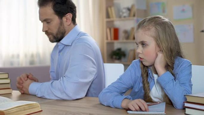 敏感的女孩子和她的父亲坐在餐桌旁无言，家庭冲突