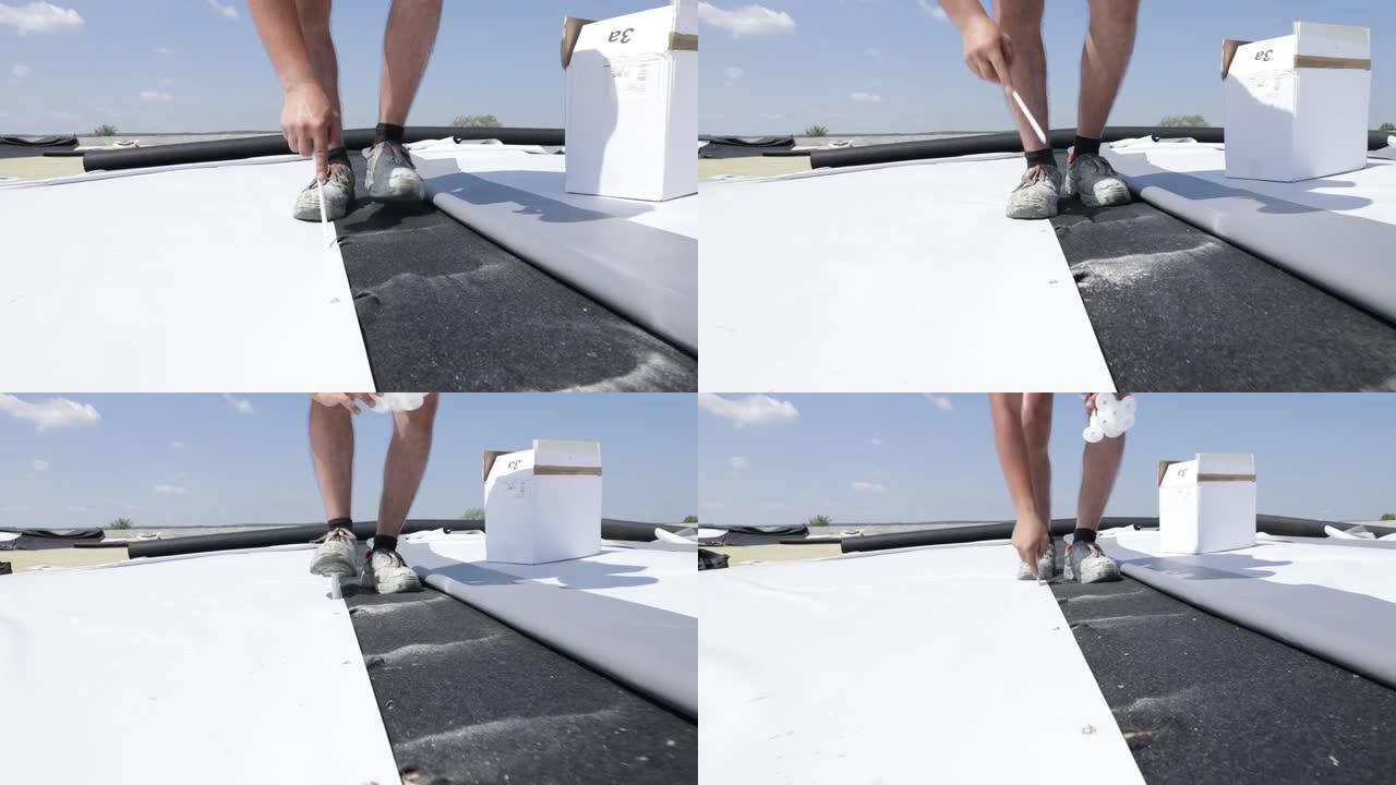 在覆盖有合成pvc膜的平屋顶上工作的技术人员。防水系统