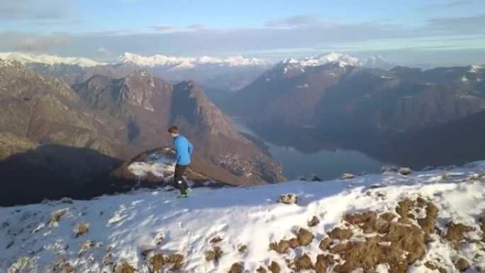 在湖泊和山脉上方的雪山山脊上行驶的步道的鸟瞰图