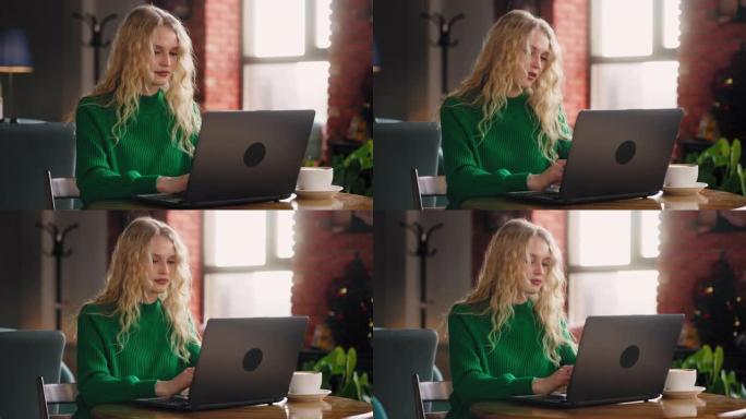 远程连接: 白天，金发女人在舒适的咖啡馆里有效地在笔记本电脑键盘上输入消息，在线聊天