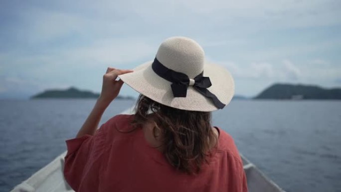 一名年轻女子在岛屿附近的一艘小船上的特写镜头