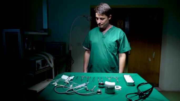 4K，医生穿着只有在手术时才穿的绿色长袍，医生站在手术台前，用手术器械放置，医生弯腰检查机器是否准备