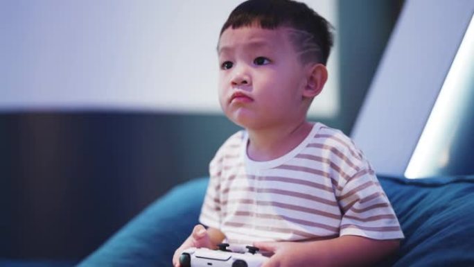 男孩使用游戏控制器在客厅玩视频游戏