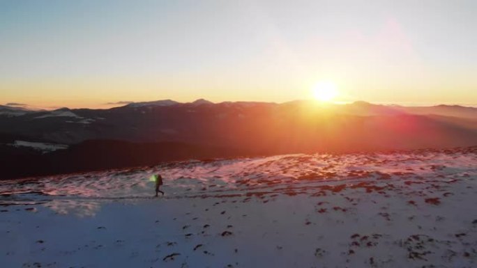 鸟瞰图的男性徒步旅行者上升通过冬天的雪在山上