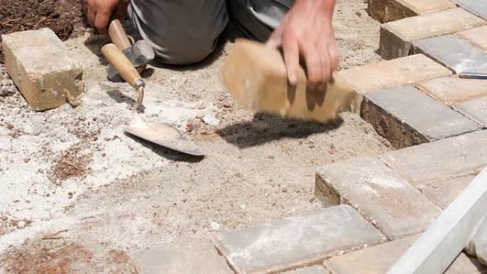 巴西和建筑工人使用抹子和槌来铲平沙土。