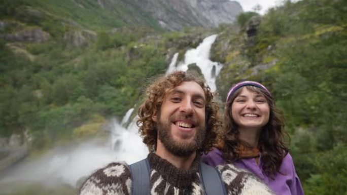 挪威山瀑布背景下的男人和女人自拍