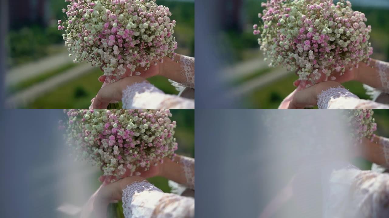 女人拿着一束白色和粉红色的小灌木花。婚礼当天的新娘。