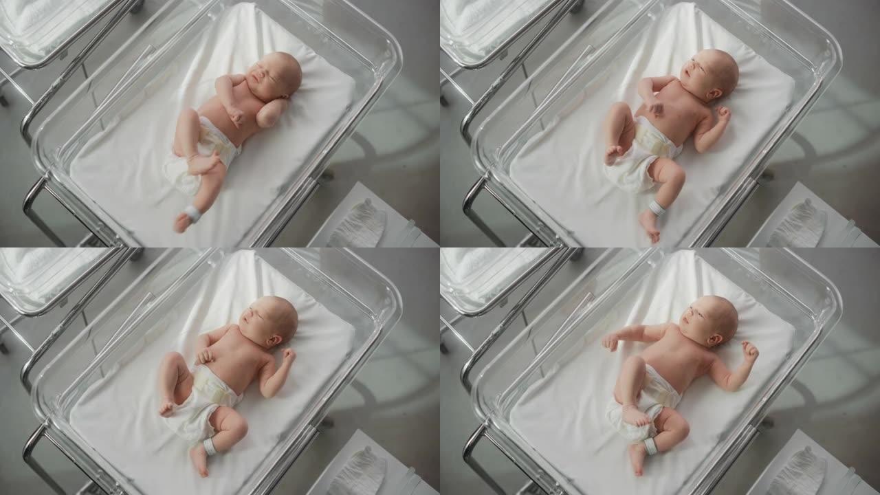 可爱的小高加索新生儿躺在托儿所的病床上。顽皮健康的小宝宝。医疗保健、生育和生育概念。自上而下的肖像