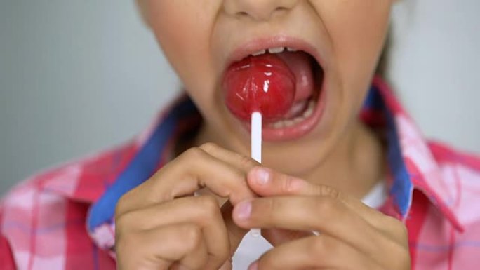 女孩试图咬棒棒棒糖，糖对牙齿的不良影响，牙齿护理理念