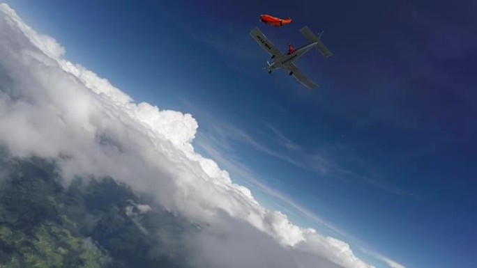 翼服飞行者从瑞士山脉和农田上方的飞机上跳下来