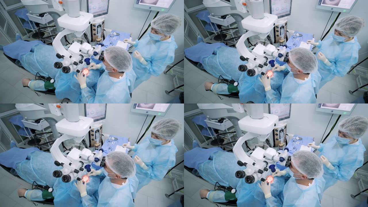 眼科手术专家坐在显微镜前进行手术。低角度视角的女医生进行高精度手术。Femto激光辅助白内障手术。