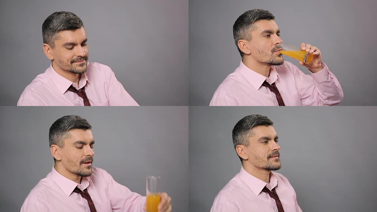 迷人的男人喝新鲜的橙汁，享受品味，健康的生活方式