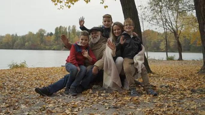 幸福家庭在秋季公园挥动双手放松