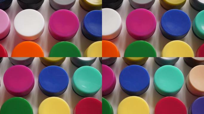 将水粉画颜料放在罐子里明亮的颜色特写。塑料罐上的多色水粉套装。多莉拍摄多色背景。多色油漆的背景。创意