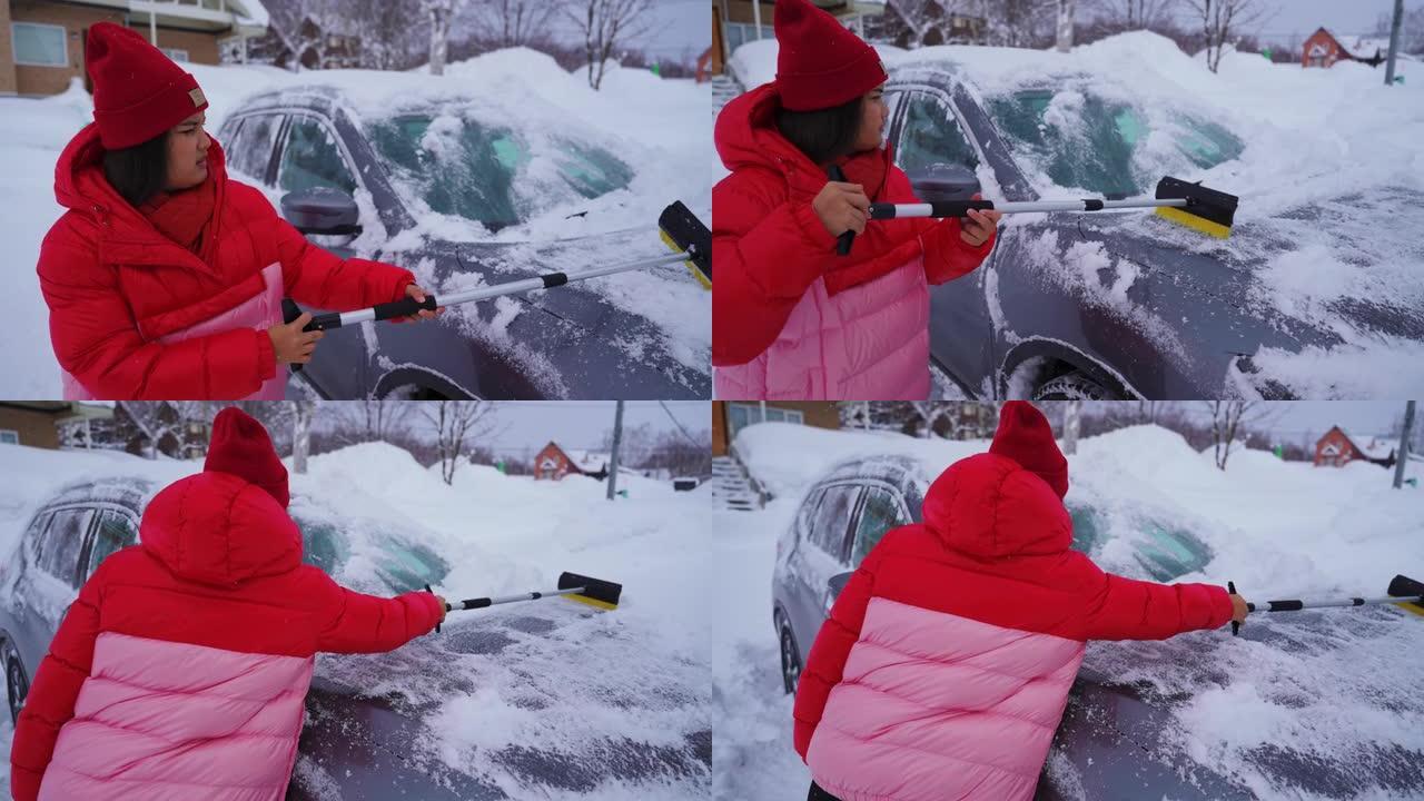 女人清理汽车上的积雪