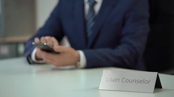 贷款顾问使用智能手机，为客户提供债务结算服务
