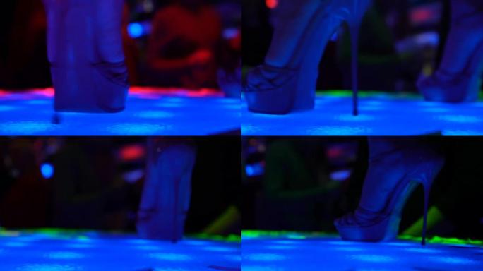 脱衣舞女穿着高跟鞋在舞台上跳舞，夜店里的摇摆舞表演